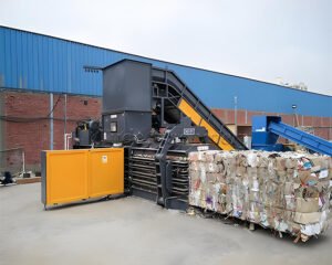How does a hydraulic waste material baler work?